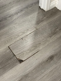Flooring is buckled and has rough edges.