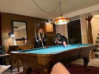 The 20 and 15 year olds taking each other on in a game of pool.