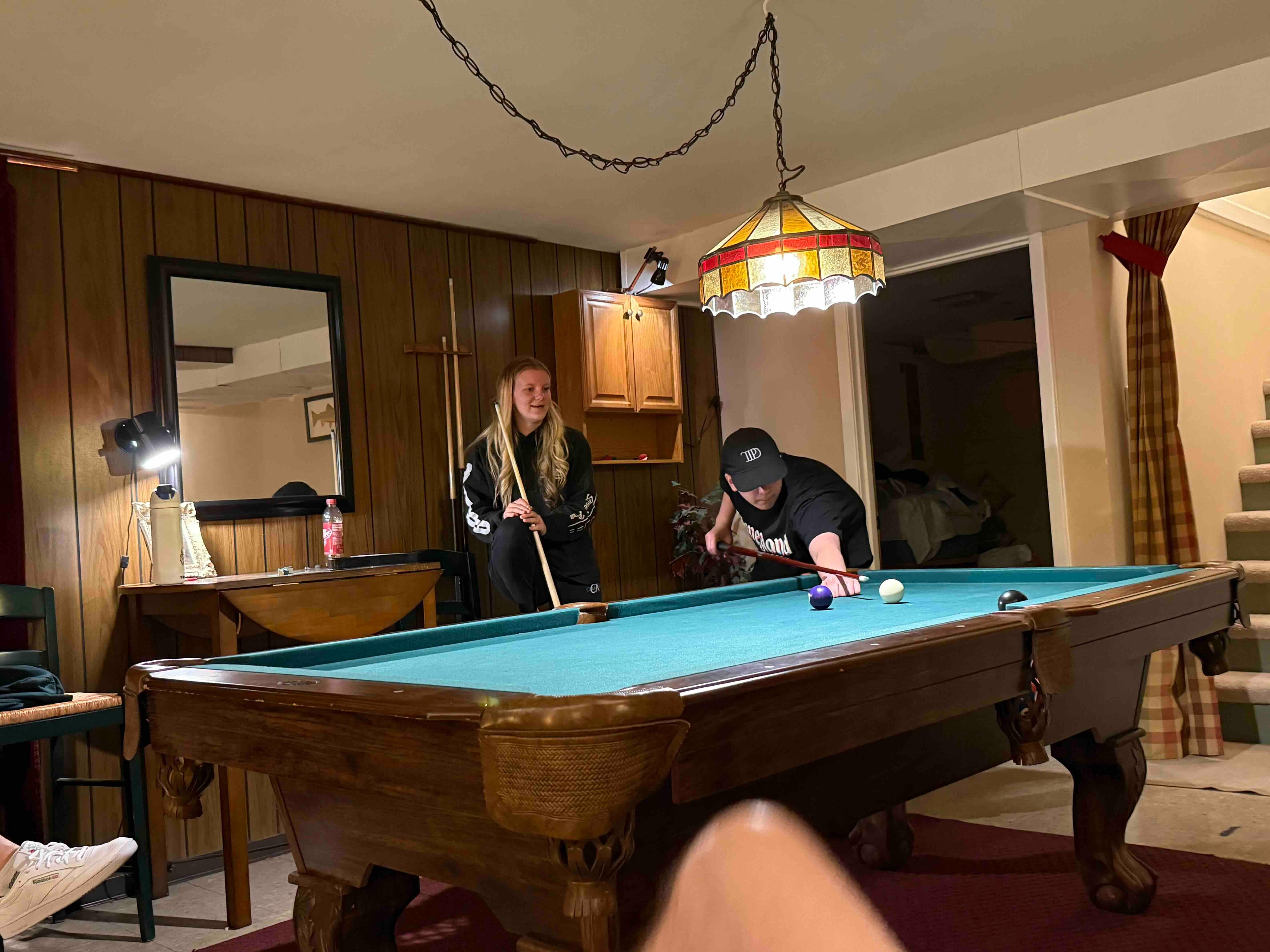 The 20 and 15 year olds taking each other on in a game of pool.