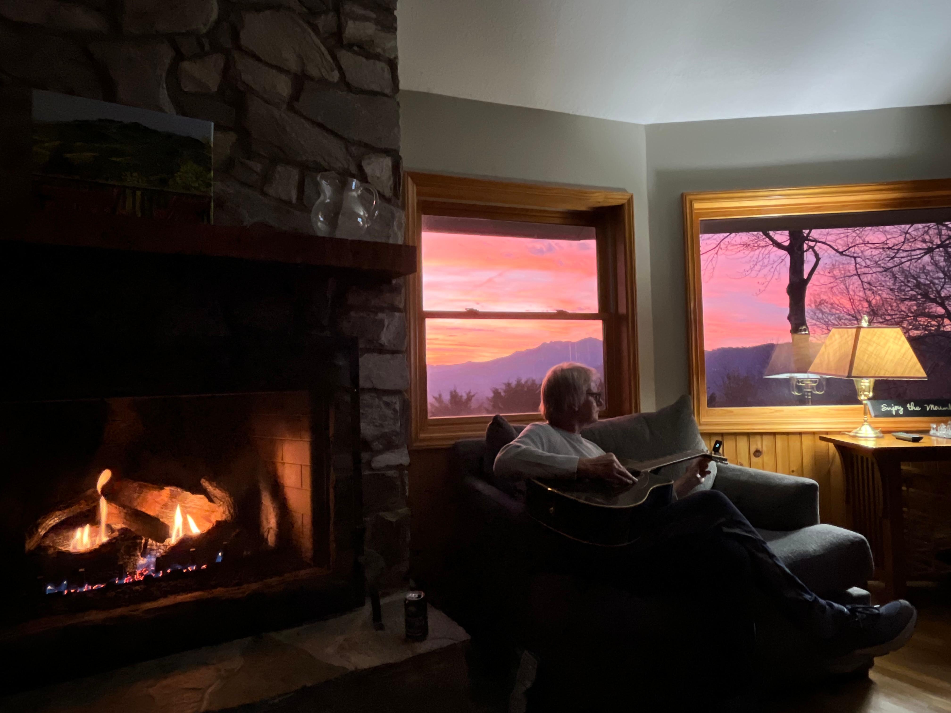  Playing guitar by cozy fire at sunset