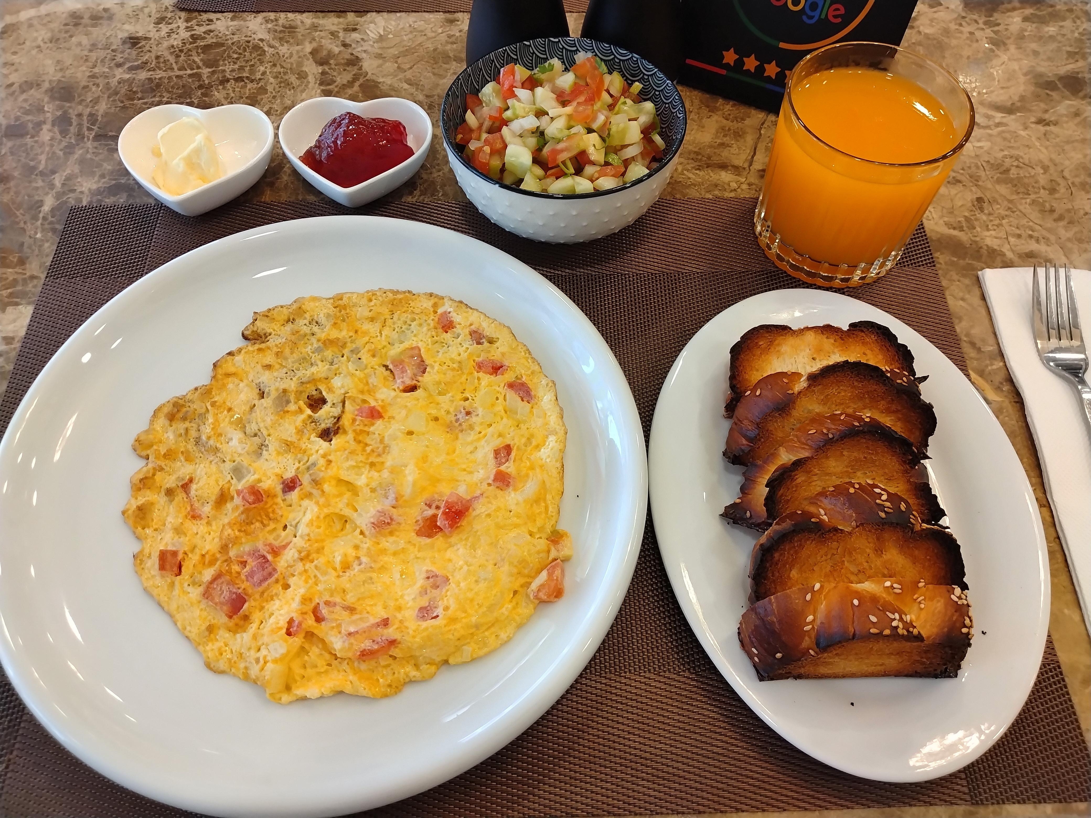 朝食。卵はオムレツか目玉焼きかスクランブルエッグを選べ、飲み物はオレンジジュースかコーヒーが選べる。