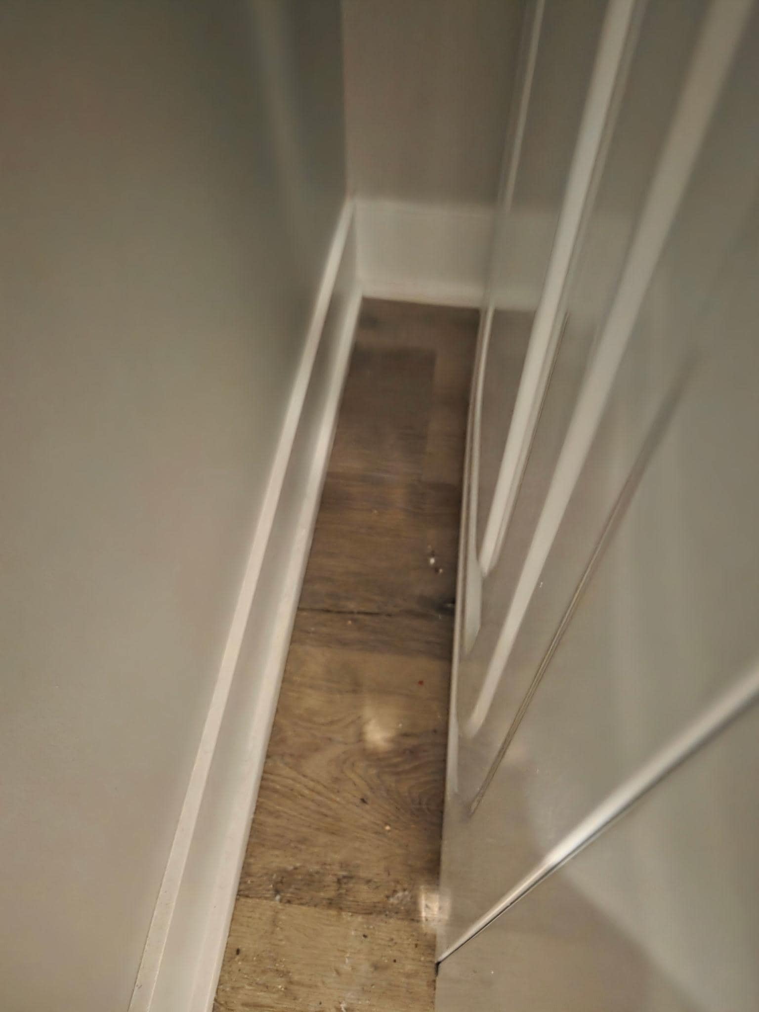 Dust and trash next to the washer.