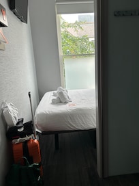 That is very close to the wall. Bed sits extra high, so suitcase can fit underneath.