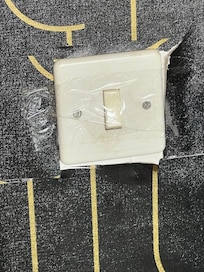 Mit Klebeband fixierter Lichtschalter