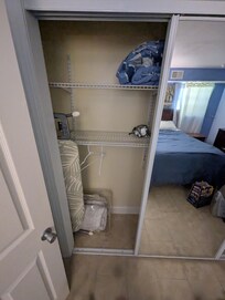 The other side of the previous picture's closet, including ironing board, irons, comforters and other spare bedroom amenities that the host had available for our use in the downstairs floor, which was all ours, as of May 16, 2026.