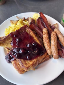 My breakfast! Soft scrambled eggs, thick bacon, both pork and turkey sausage options (I chose turkey) breakfast potatoes and french toast with blueberries! Well worth the $10 we paid.