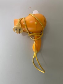 A retro touch. Original hairdryer in perfect orange. And a touch sensitive bedside lamp