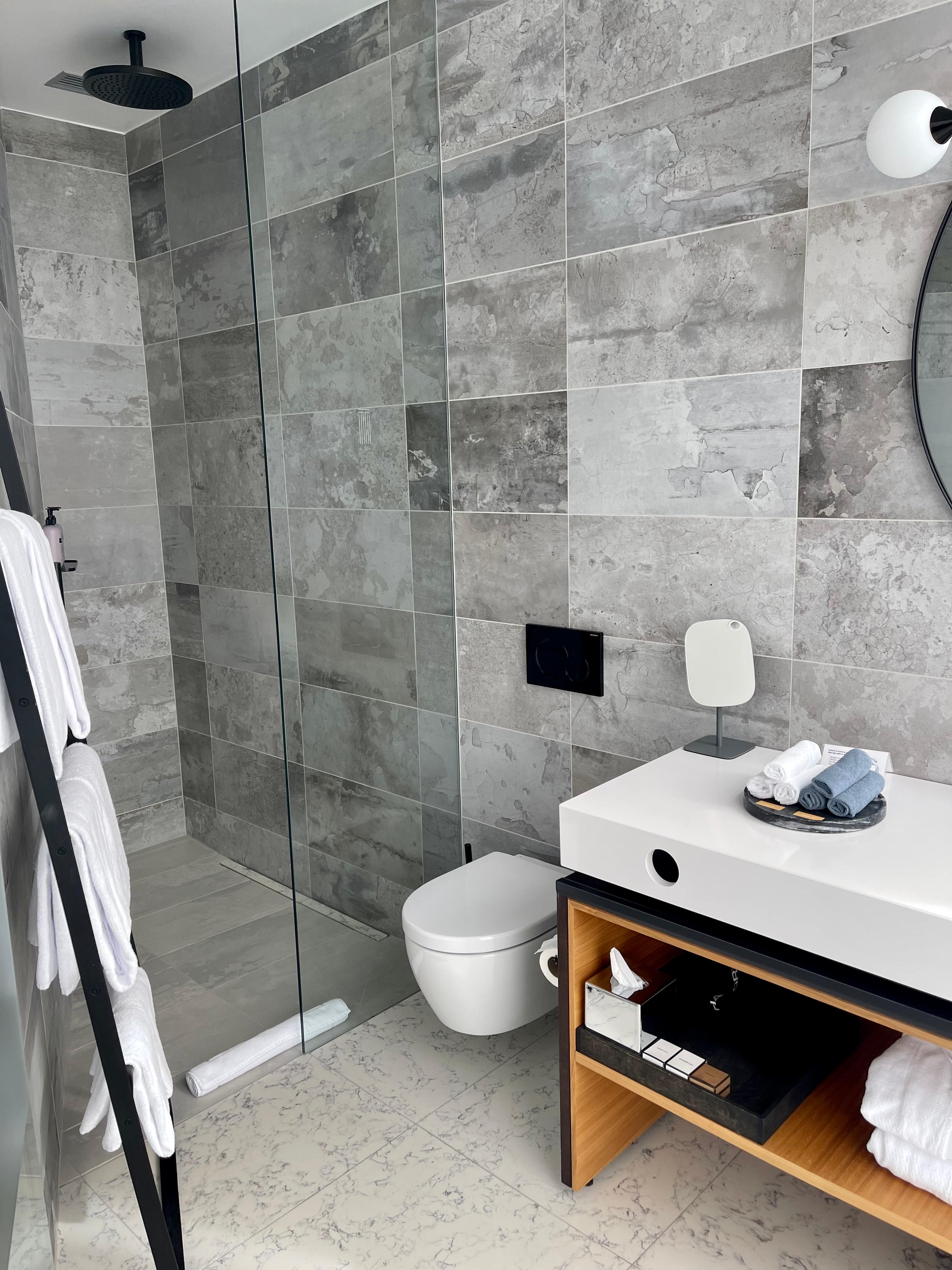 Well stocked bathroom with rainfall shower plus shower spray handle