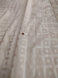 Hole in bedspread from cigarettes in a non-smoking room