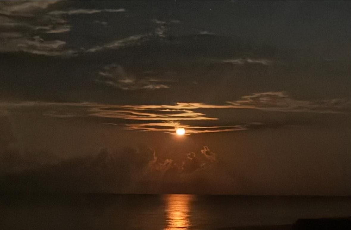 Moon shining on water at night