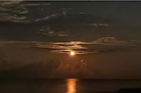 Moon shining on water at night