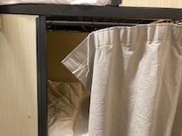 Broken curtain hanger that leaves part of the bed uncovered