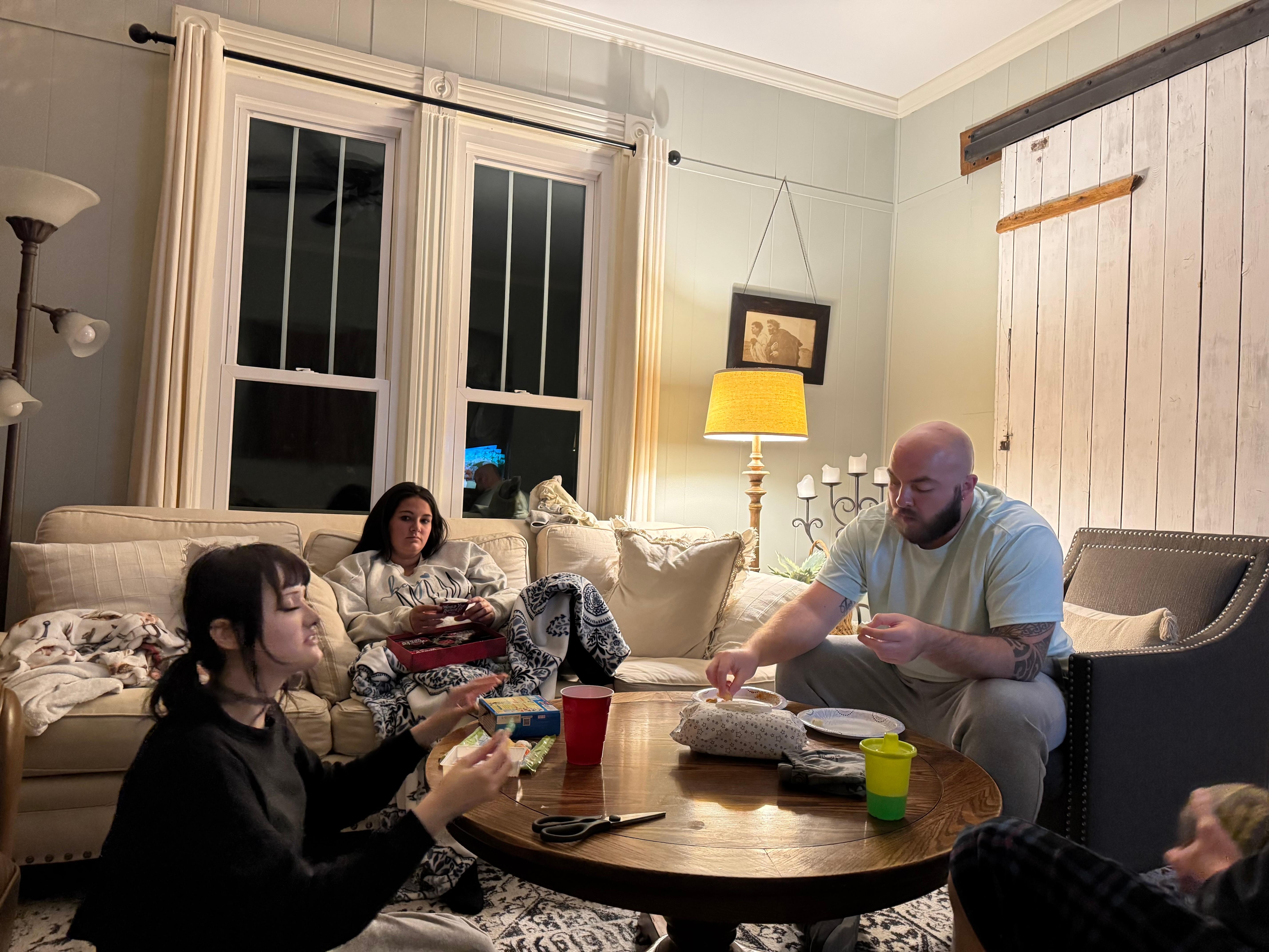 Three generations gathered in this room playing games.