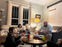 Three generations gathered in this room playing games.