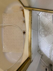 Bottom of the shower where you can see the wear and tear, which was initially covered by the mat