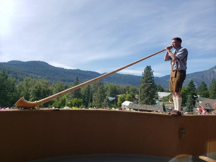 alpenhorn player on balcony during breakfast