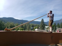 alpenhorn player on balcony during breakfast