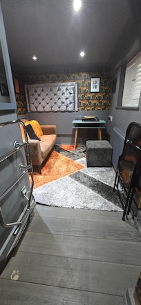 Living room w a TV & a record player. Very small windows.
