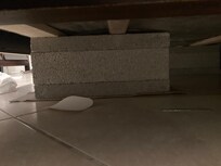 Broken bed held up with cinder block