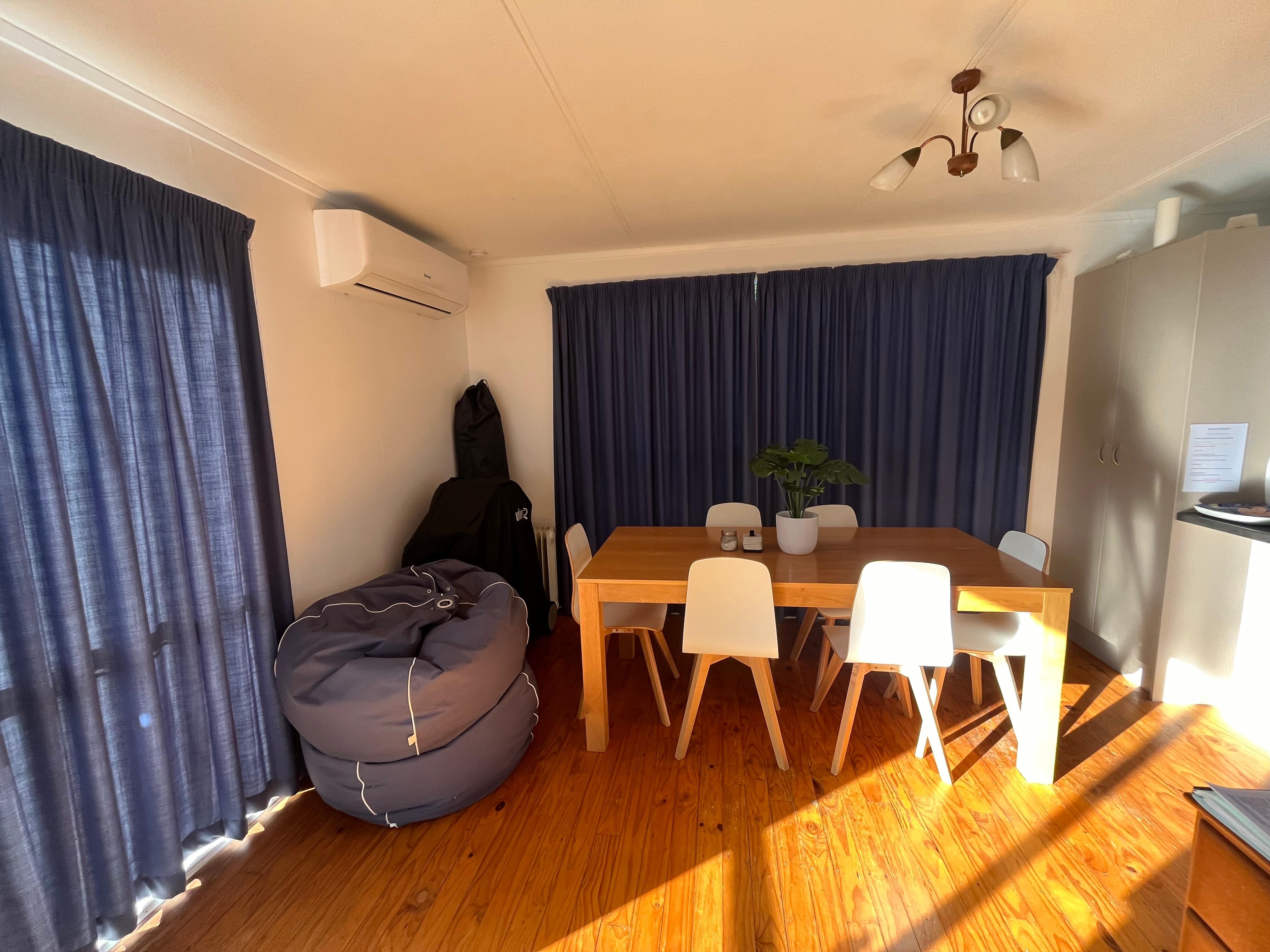 Dining area with a lovely big table and new heat pump with bean bags and a bbq