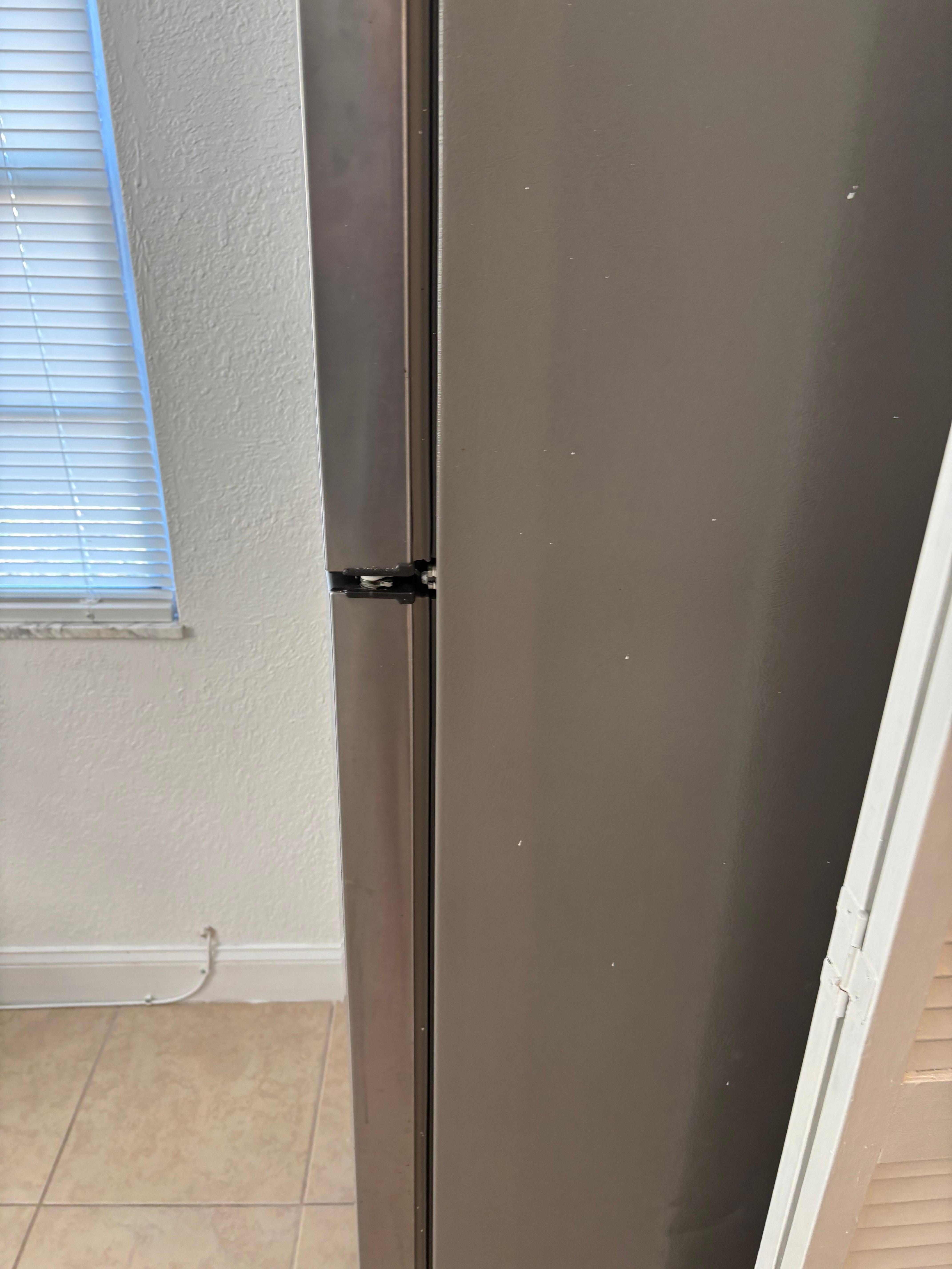 The refigerator in the living room because the so-called kitchen is too tiny to fit it