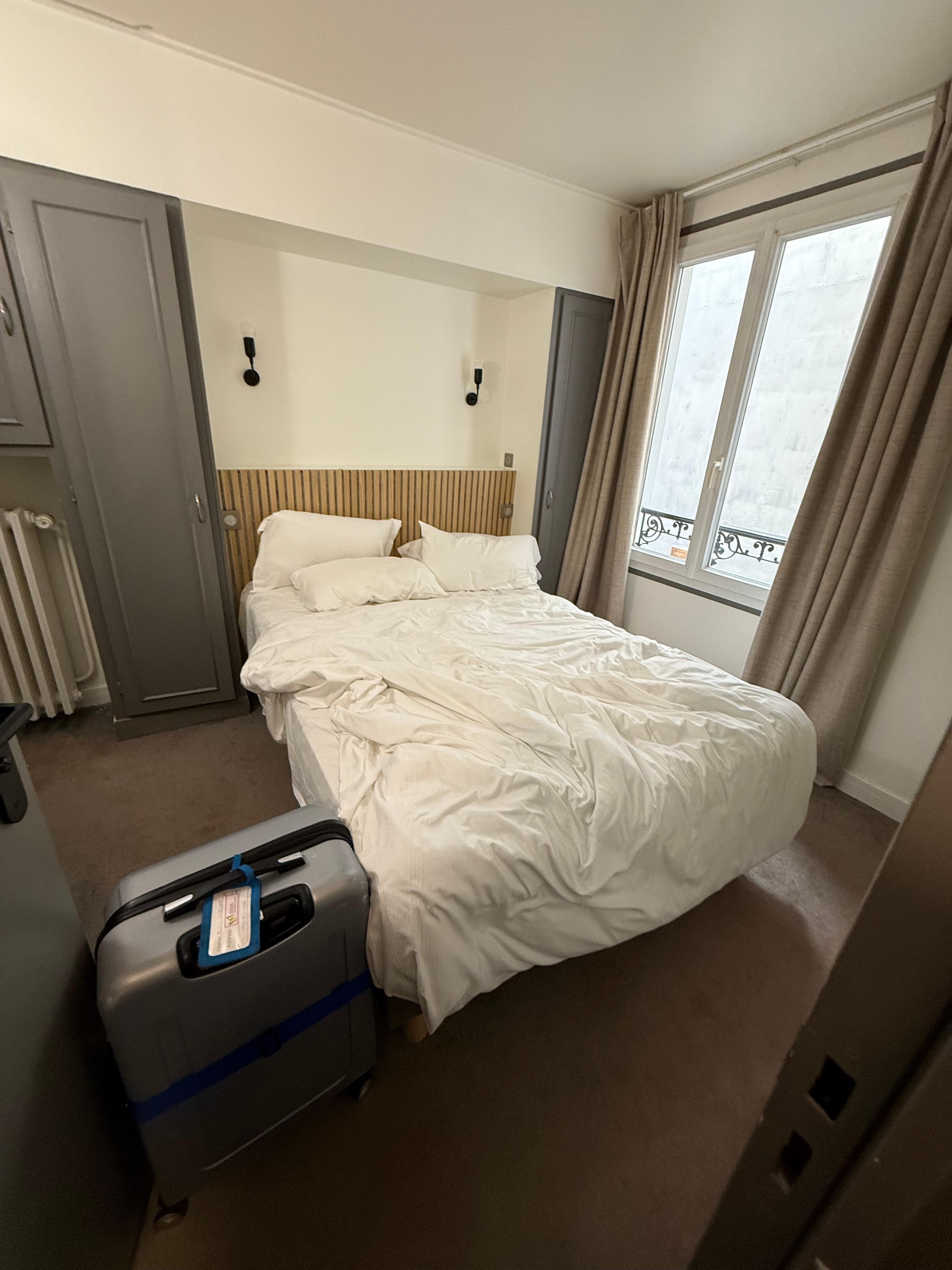 Photo of room 35 from inside the two front doors. The width of a suitcase around the entire bed.