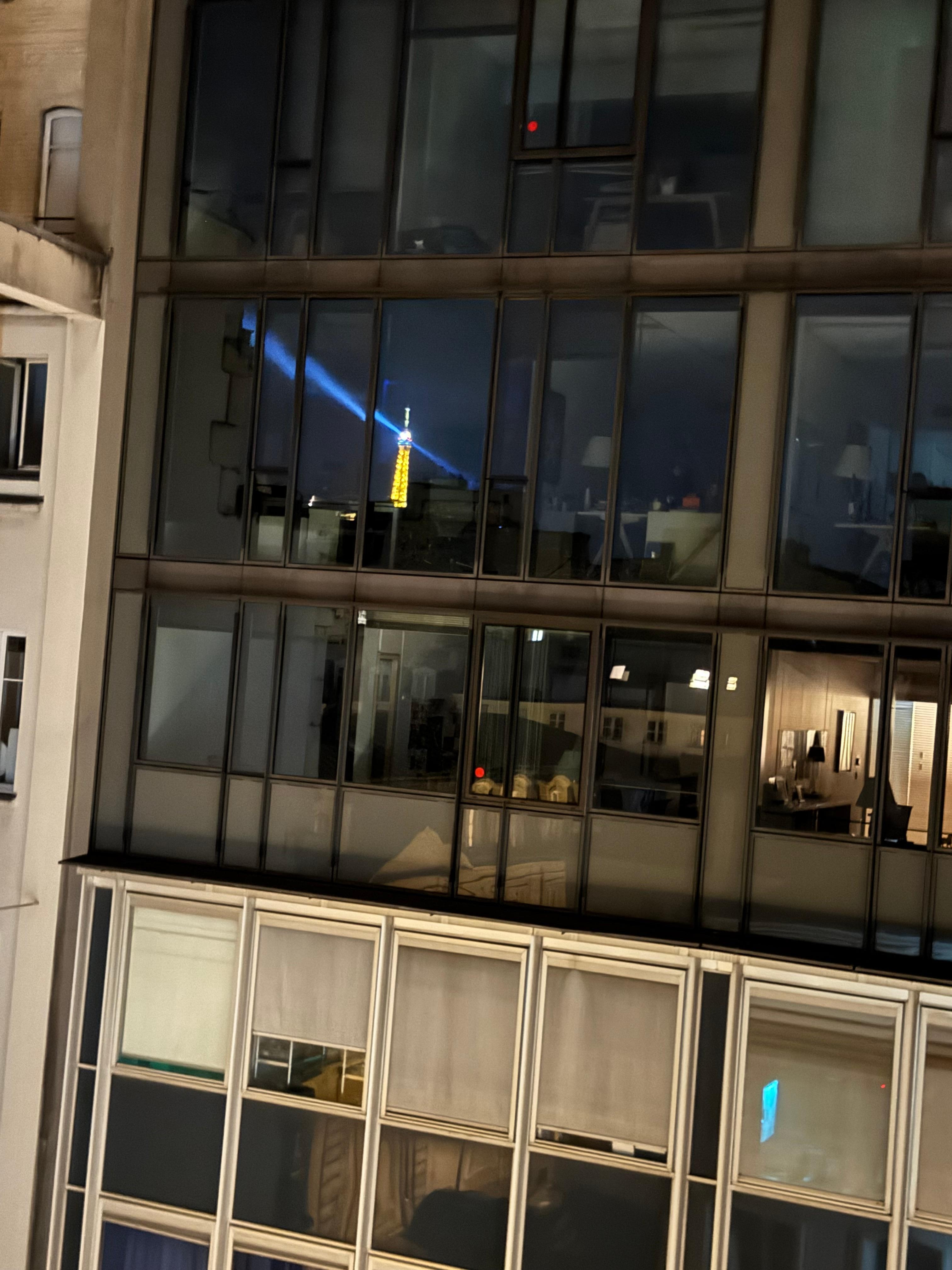 Reflection of lit-up Eiffel Tower taken from balcony
