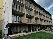Carpet sitting outside in rolls. Garbage on balconies