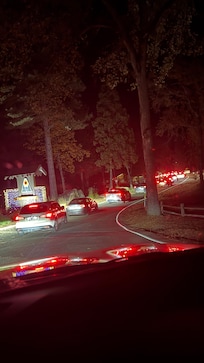Line of cars waiting to get in through the gate of the compound.