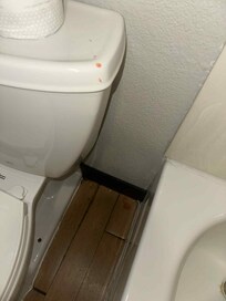 Melted candle wax on the toilet and floor