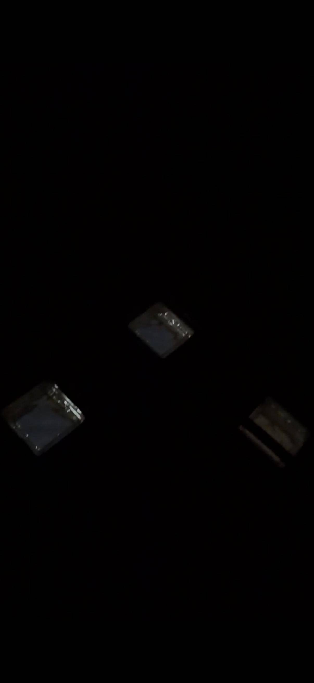 Dark view of glass tiles above bed