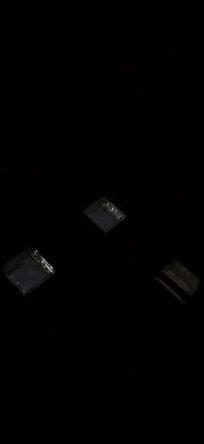 Dark view of glass tiles above bed