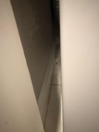 Dirty floor beside washer