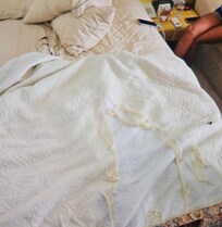 Tattered comforter at the foot of bed 2