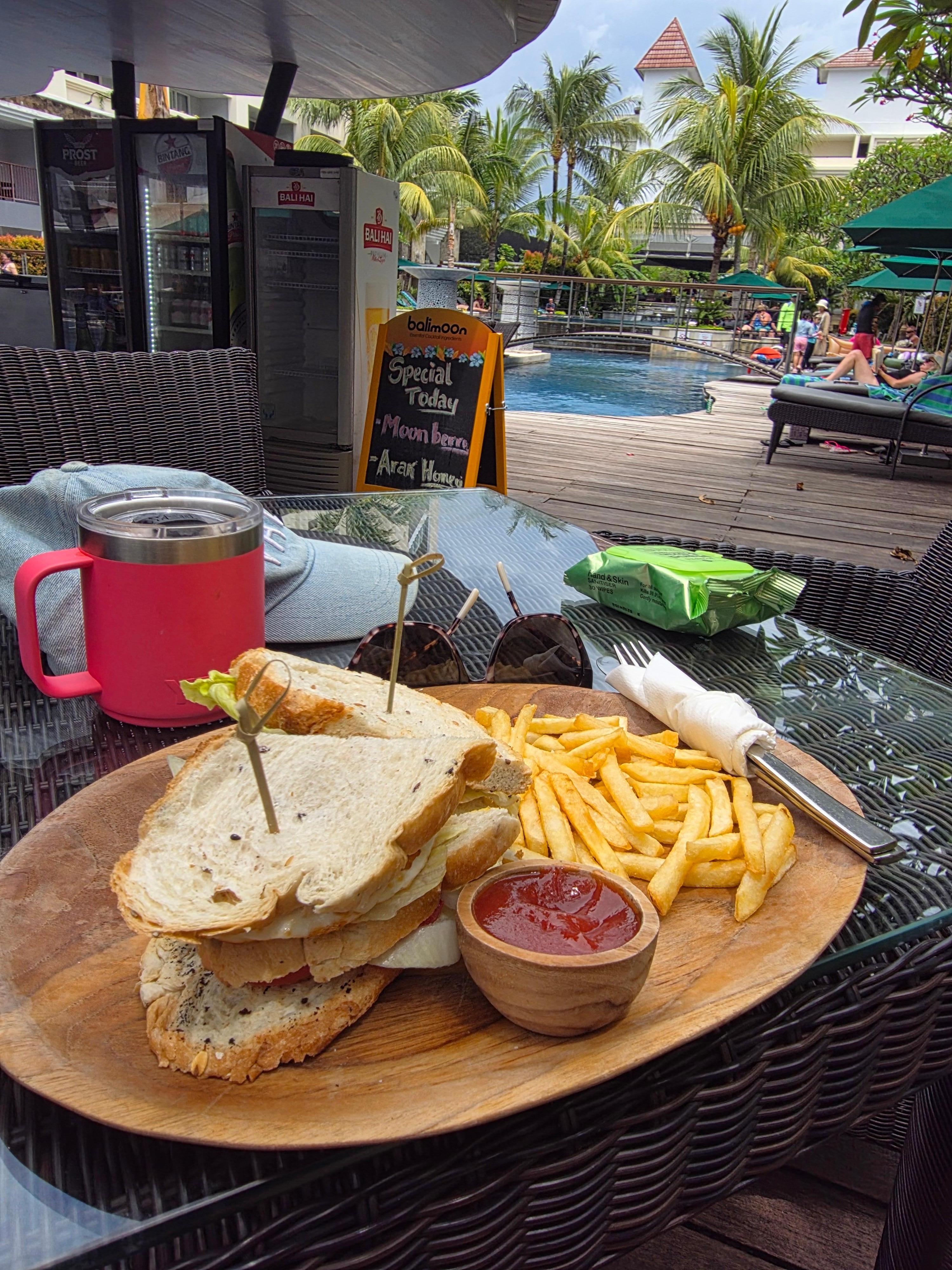 Poolside food, chicken & salad sandwich with fries.