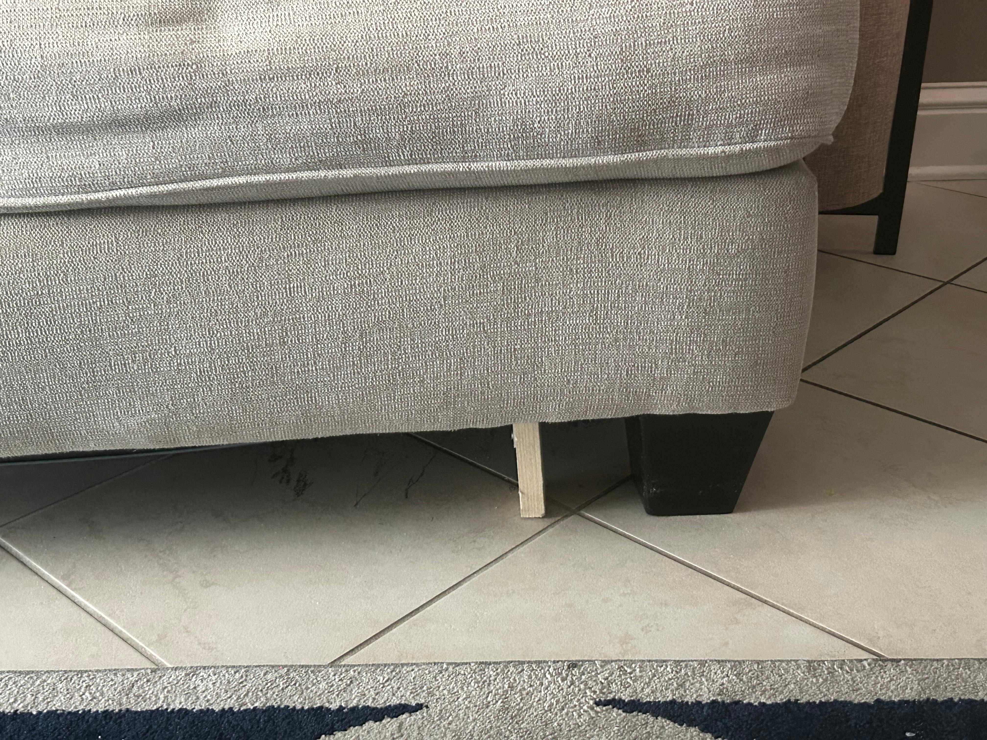 Couch held up by wood block