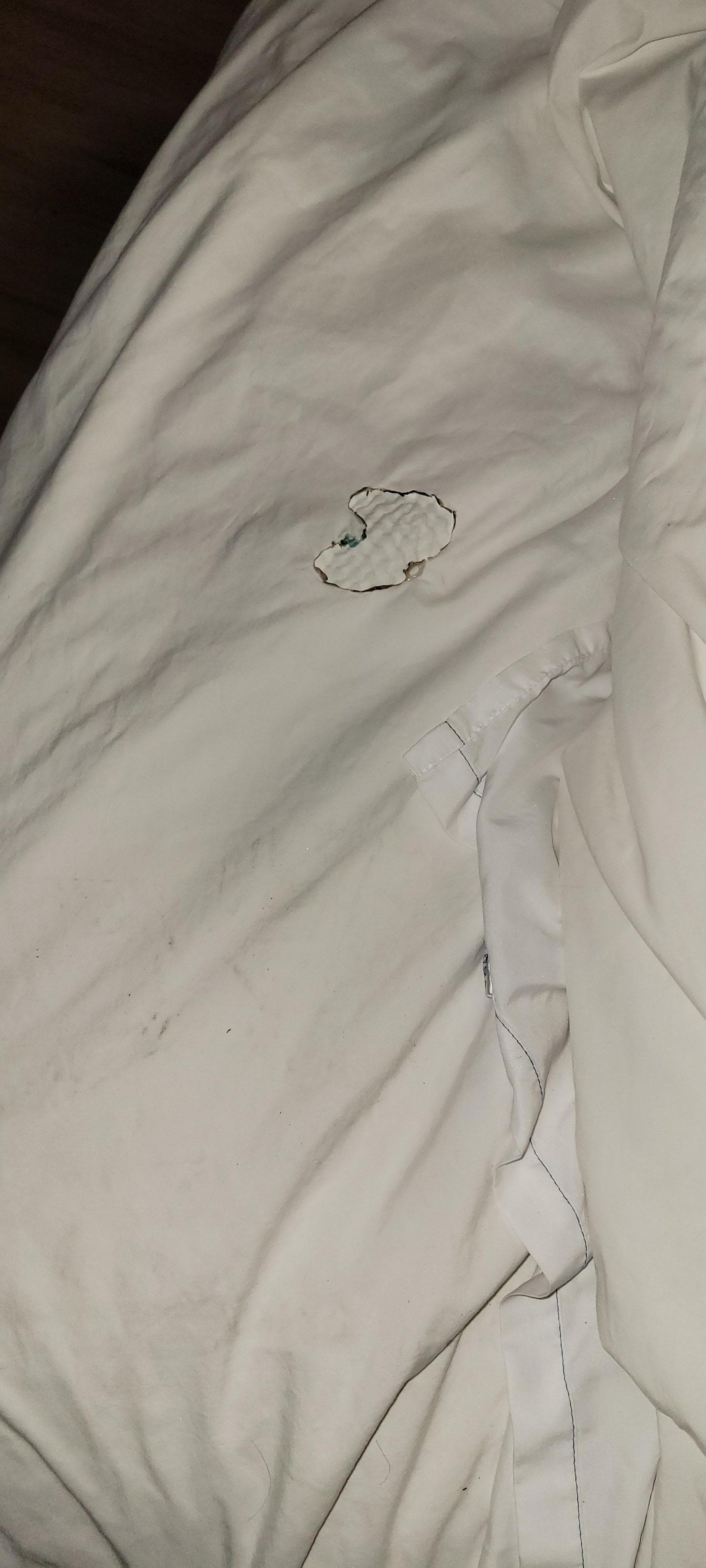 Hole in bed cover appears to be a burn hole