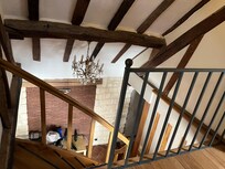 Stairs from second-story bedroom/bathroom down to living/kitchen and downstairs bathroom