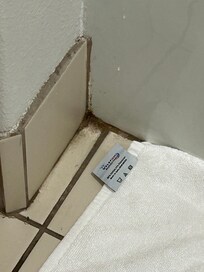 Dirt in the corners of the bathroom floor