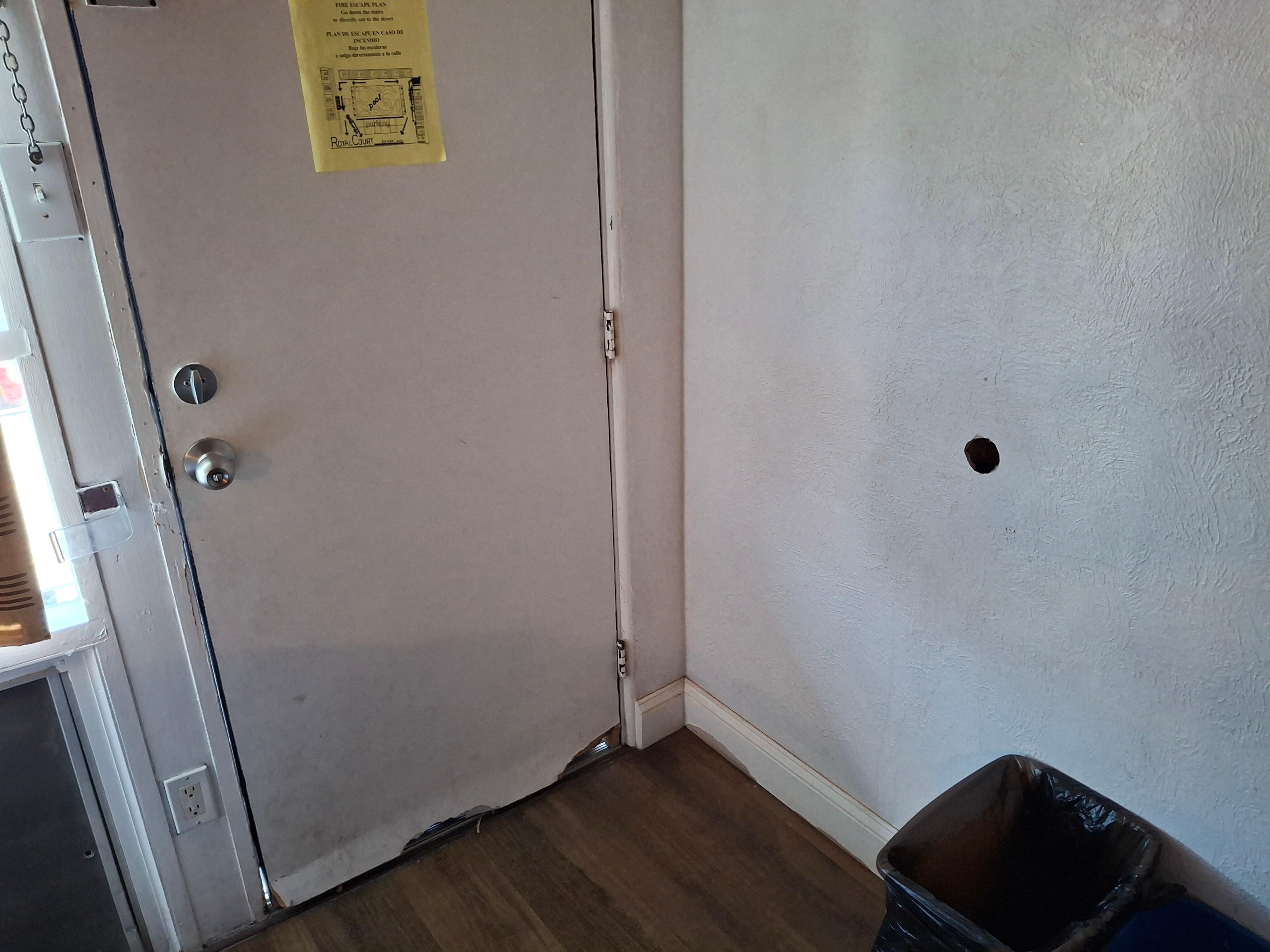 Hole in wall from door.  Adjacent room also had the same and you could look thru into the other room.