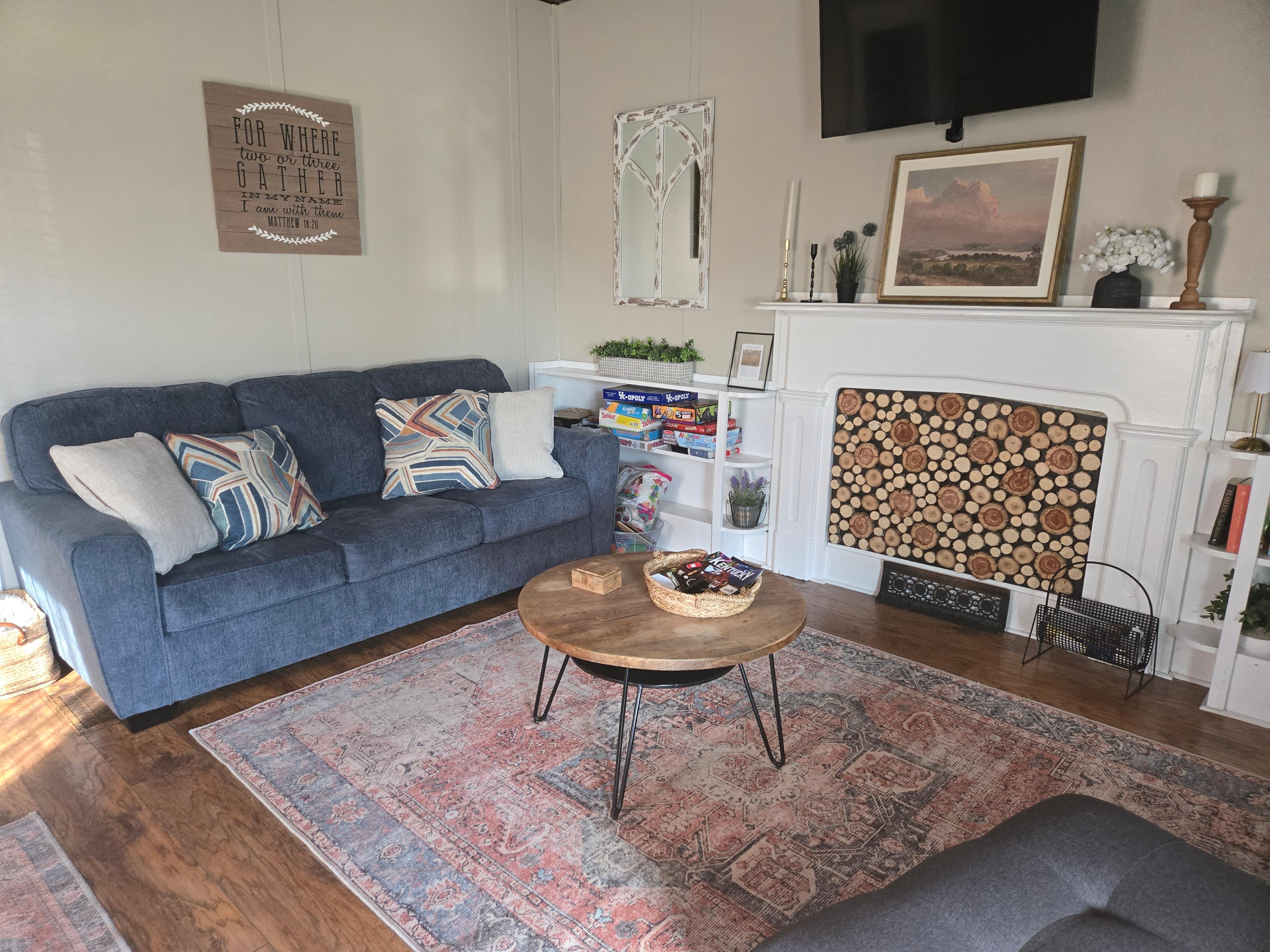 Showing the cozy living room and if you notice, there are games and books to enjoy.