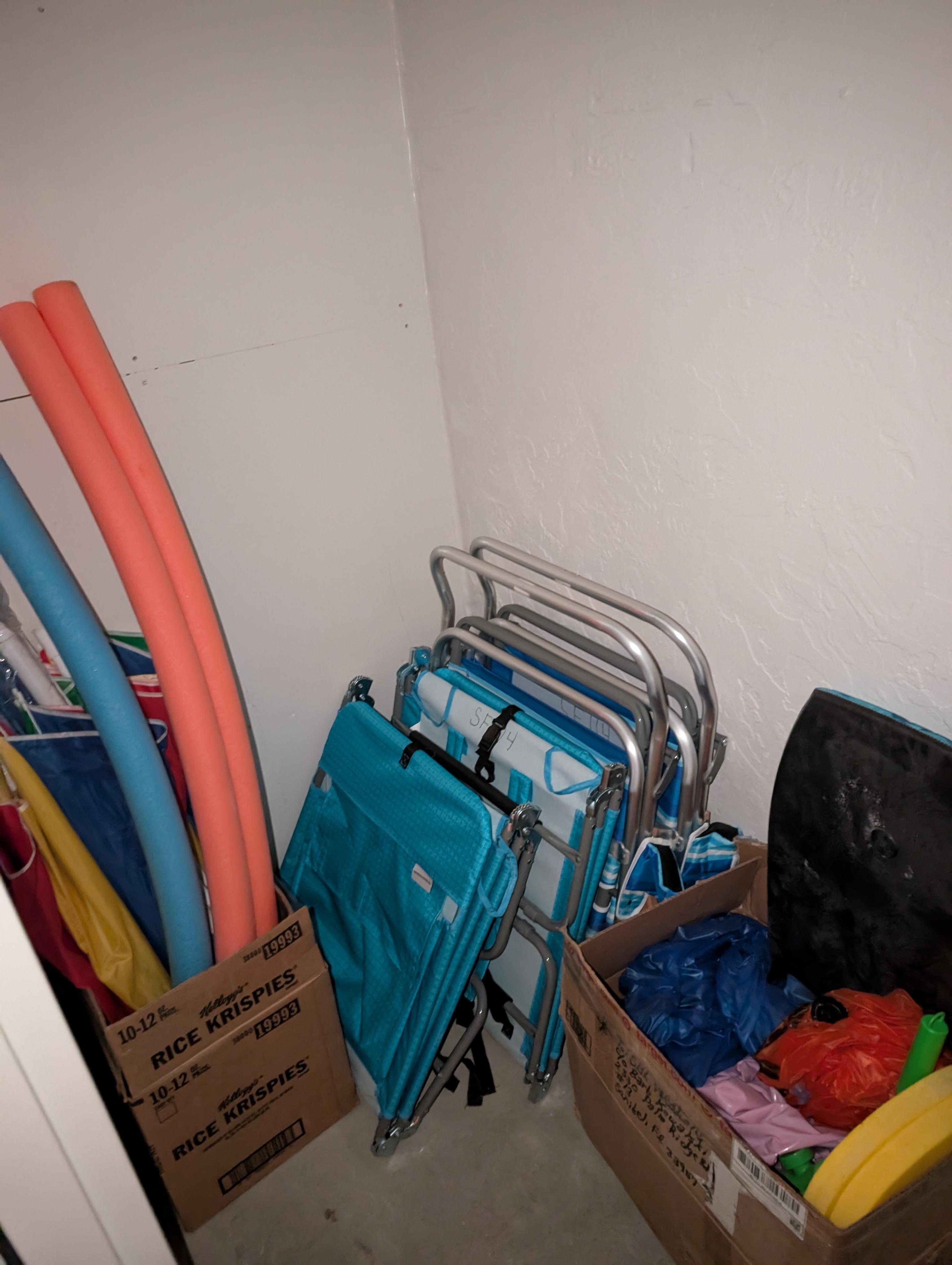 Well equipped storage closet with chairs and umbrellas.