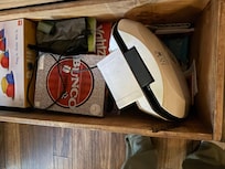 Not sure why a dirty georgeforman grill was not placed in the kitchen that had plenty of space but put with a bunch of board games .