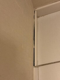 Bathroom tile at the intersection of the wall and floor coming loose