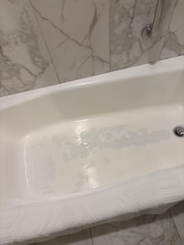 The paint chipping on the bottom of the bathtub.