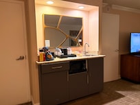 Mini kitchen area including a sink, mini fridge and microwave along with coffee maker and complimentary coffee and tea
