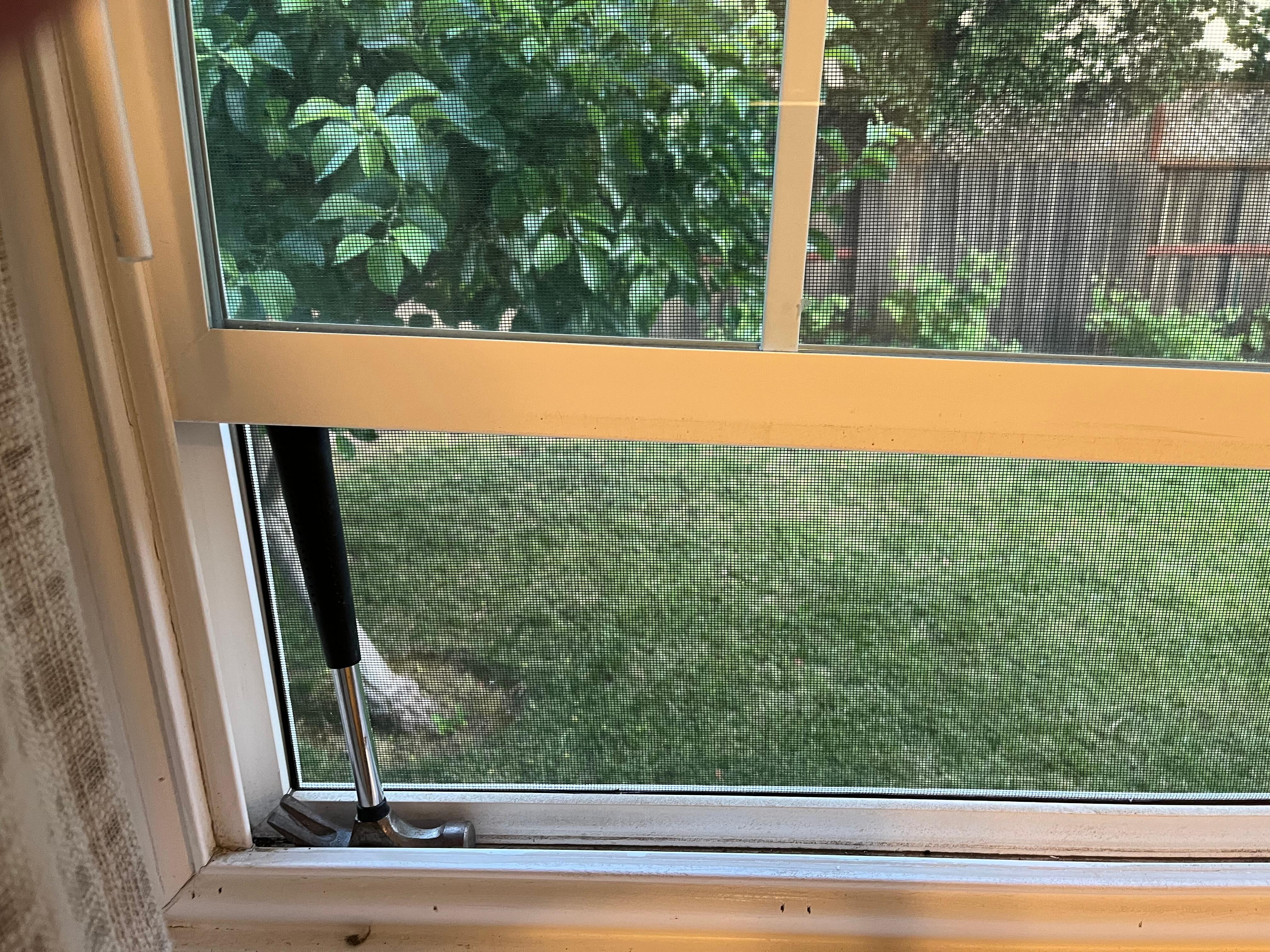 Window propped up with hammer