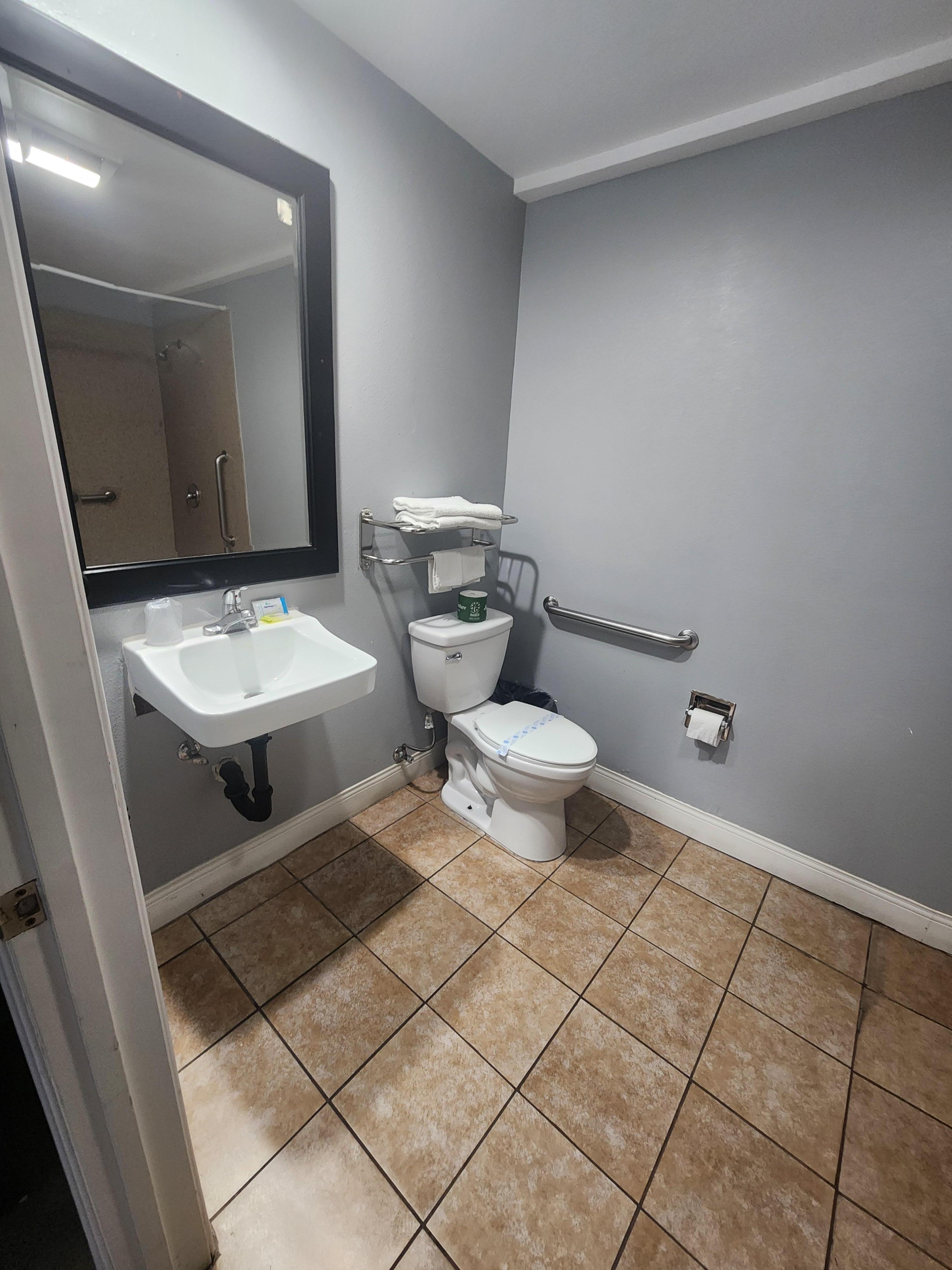 The toilet paper was rolled up in a sloppy manner as if it had been unrolled and then quickly rolled up. 