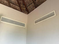 thatched roof with rusty air vents