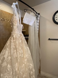 The shower rod in the primary bath is strong enough to hang a heavy wedding dress for steaming. An outlet is close enough for a steamer to reach it (a concern mom had prior to wedding).